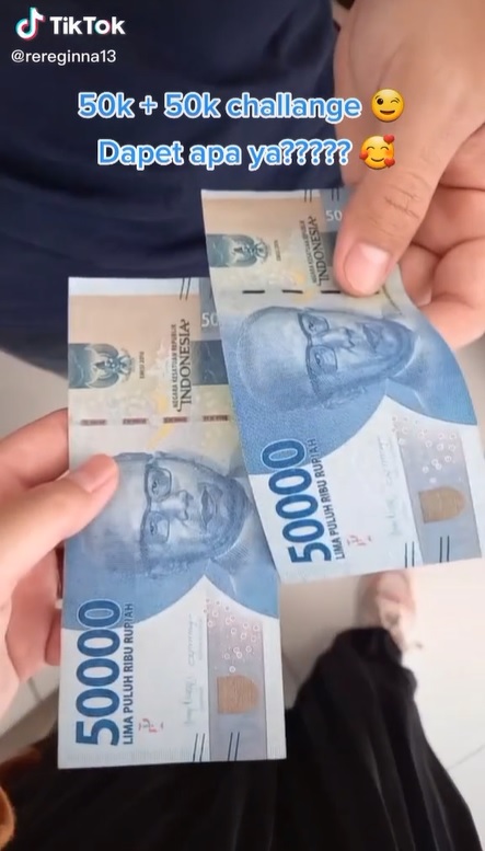 Lembaran uang Rp 50 ribu sebanyak dua lembar yang ditunjukan pasangan suami dan istri.