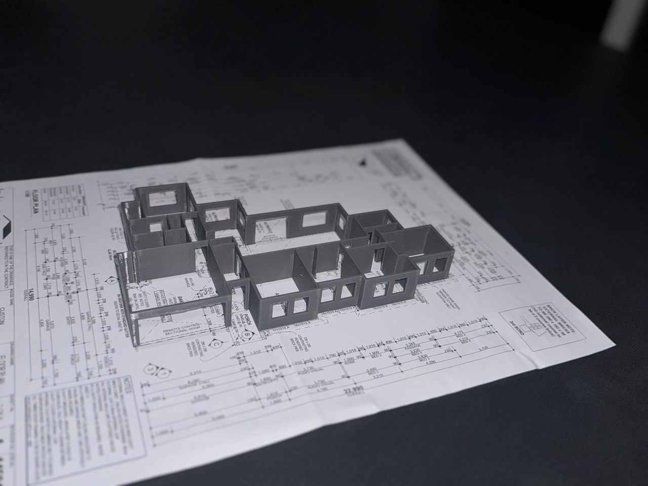 3D printed house model on architectural blueprint