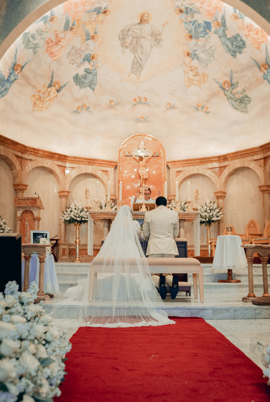 Novia y esposos arrodillados frente al altar