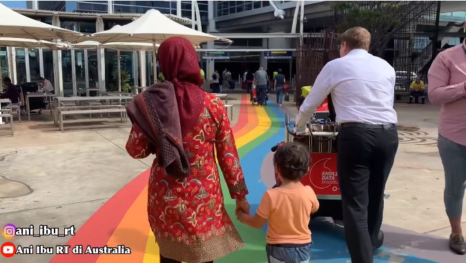 Suami Ani membawakan koper dan berjalan bersama ibu mertua