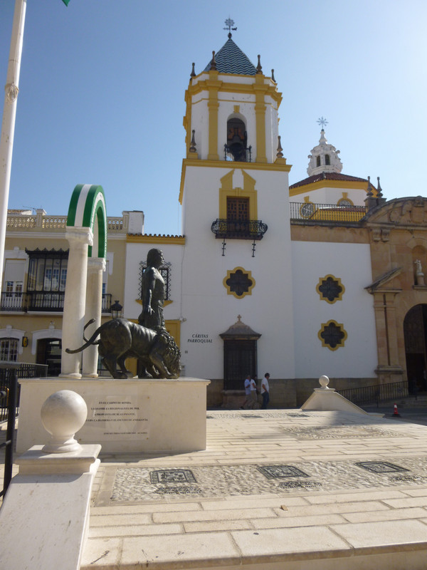 Same statue as before, taken from the left hand side.  The back of the photo therefore now shows the parish church, which is what I think is Neo-Mudéjar style.  It is plasted in white, with details like window frames picked out in mustard yellow.