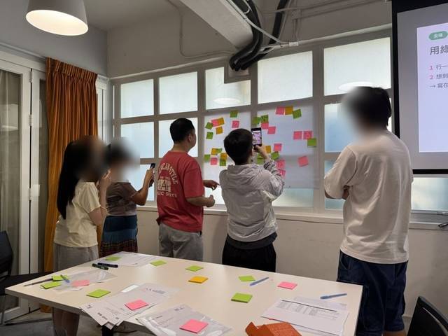 Participants looking together at a wall of sticky notes