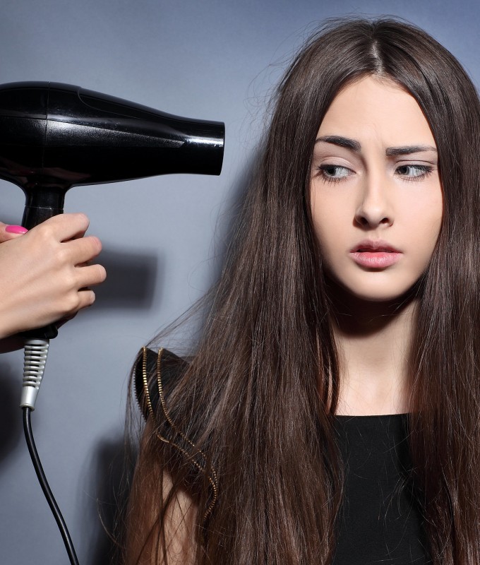 The girl avoids drying her hair with a hair dryer