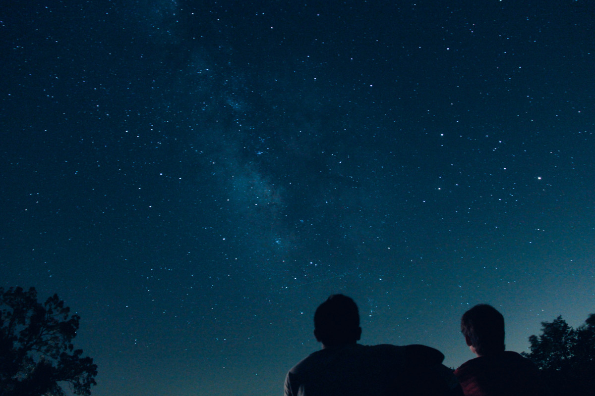 Couple-enjoying-a-stargazing-picnic-under-a-clear-night-sky-with-a-telescope