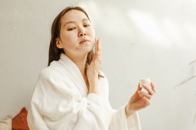 a woman applying glycerine containing moisturizer on her face that is safe for her acne-prone skin 