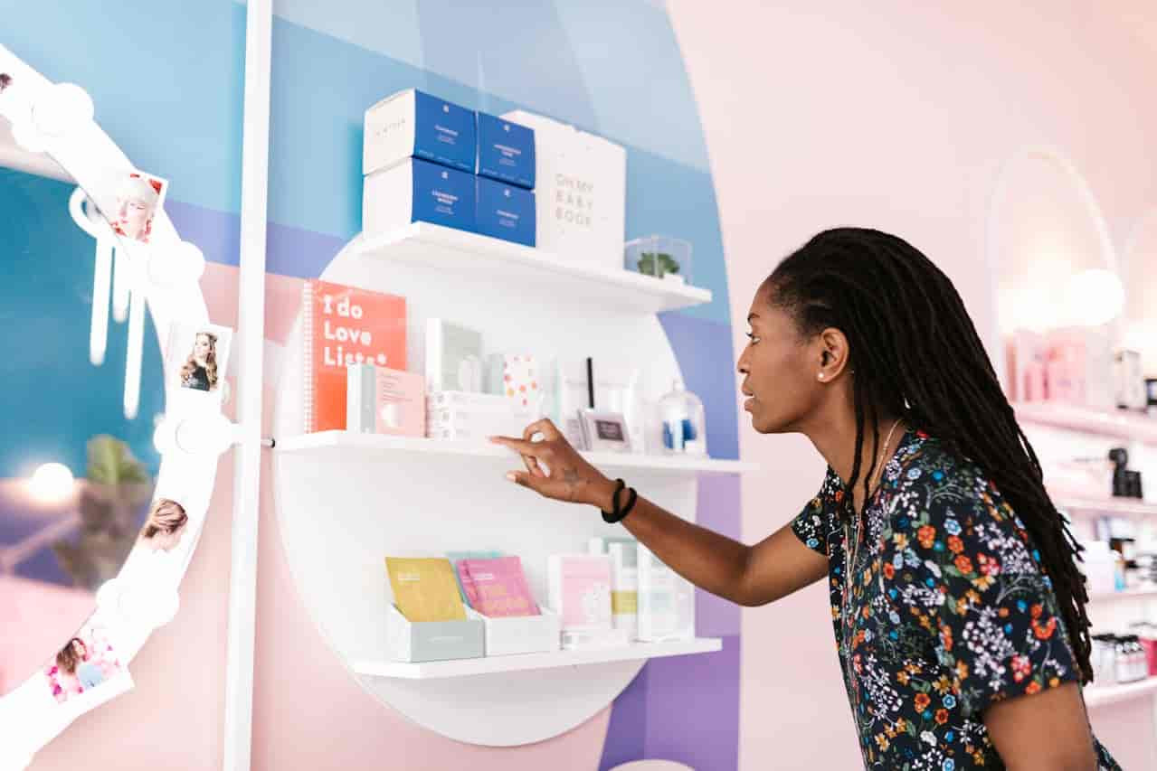 a woman standing infront a skincare shelf choosing skin care products for beginners