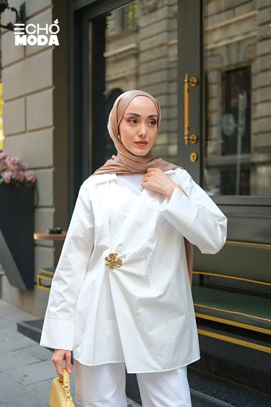 بلوزة بيضاء ناعمة مزينة بوردة على الجانب الأيسر تضيف لمسة من الجاذبية والتميّز بلوزة بيضاء ناعمة مزينة بوردة على الجانب الأيسر تضيف لمسة من الجاذبية والتميّز