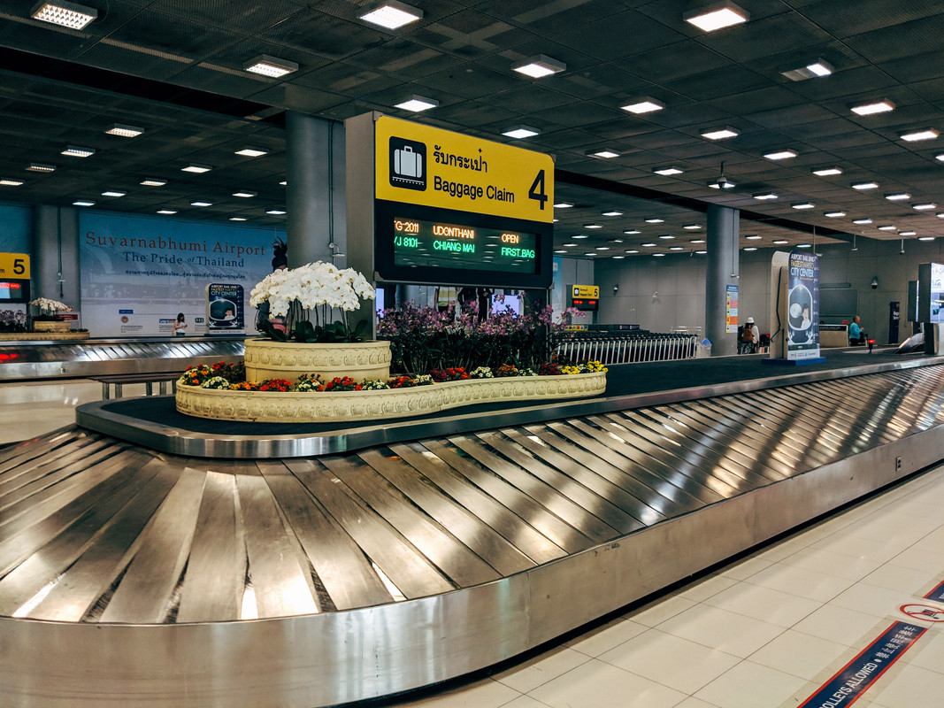 Een lege bagageband op de luchthaven in Nepal met gekleurde bloemen in het middenstuk van de bagageband