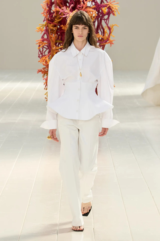 Balenciaga Summer 27, la camicia bianca ridisegnata da Piccioli Look Balenciaga Summer 27 con camicia bianca sagomata in vita e pantaloni coordinati