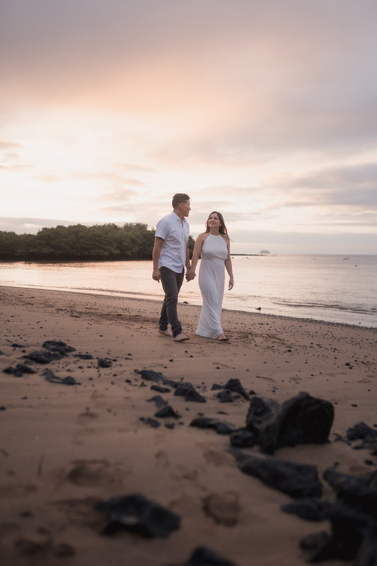Esposos caminando por la playa roja de Galápagos