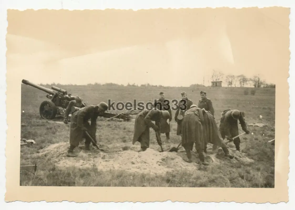 Foto Kanoniere beim Stellungsbau an schwerer Feldhaubitze mit Mündungsbremse ...