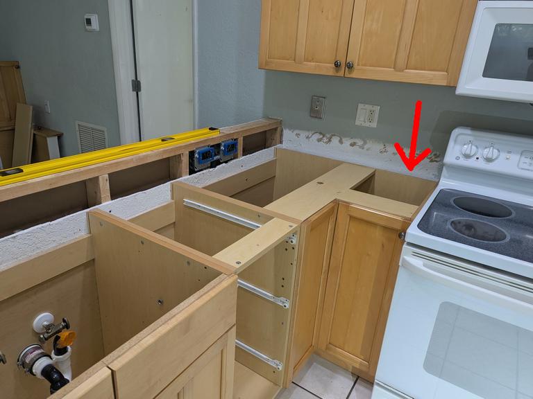 electrical junction box installed in wall stud cavity behind cabinetry