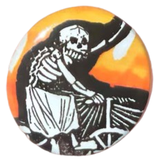 a weird pin of a skeleton with a skirt on riding a bike, outlined in black, and with an orange/yellow aura in the background behind that