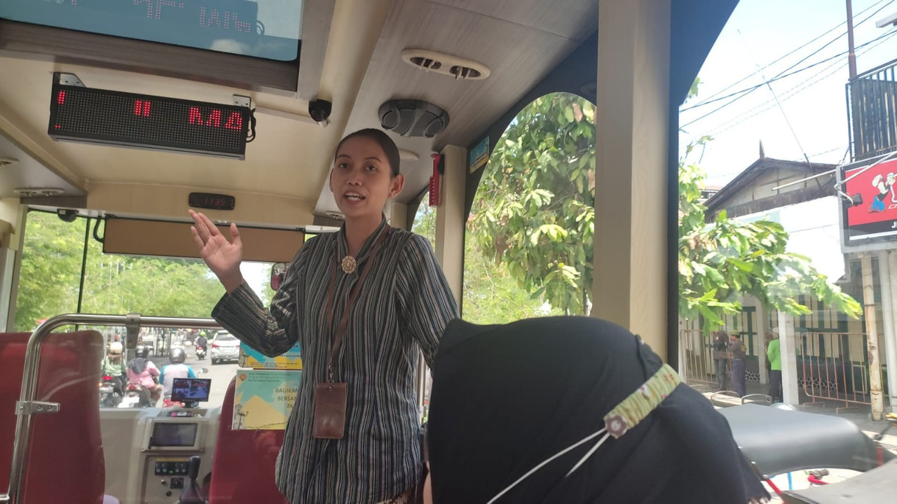 Pemandu tur bus Jogja Heritage Track saat menjelaskan tentang sejarah dan nilai filosofi setiap spot penting di Jogja, pada Kamis (6/4/2023).