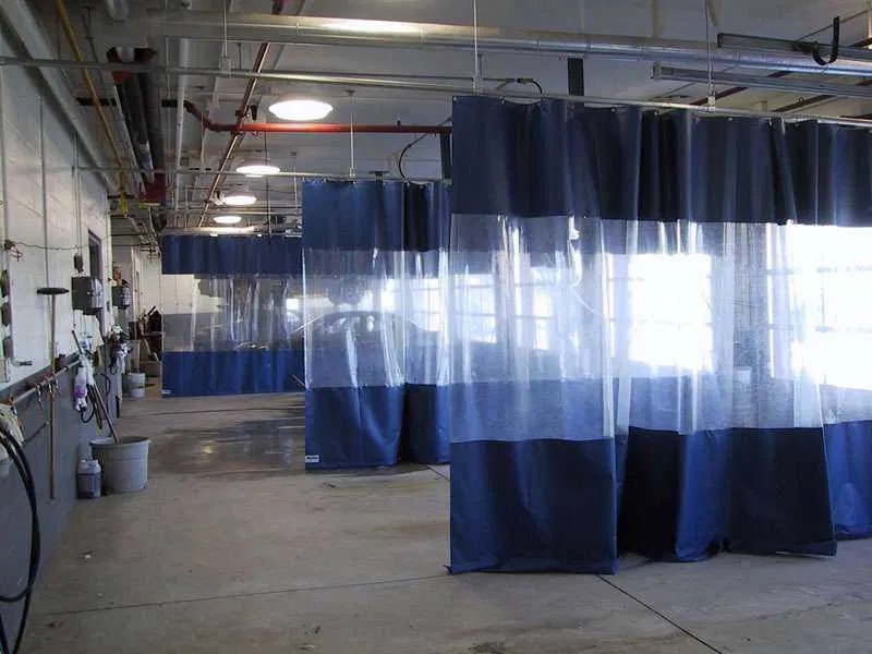 Cortinas industriales utilizadas para separar procesos y contener salpicaduras en una zona de producción