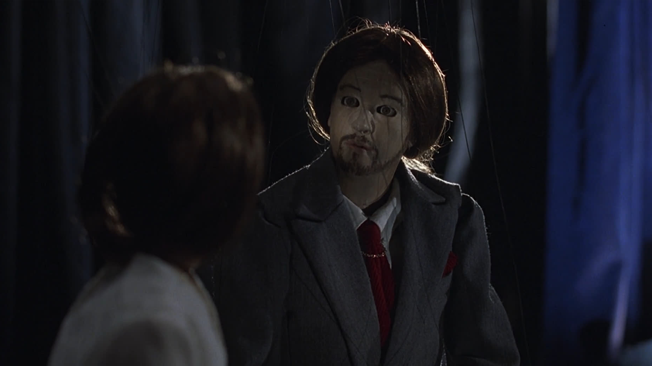 screencap do filme mostrando duas marionetes de madeira se olhando