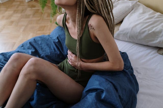 Image of a girl holding her belly, dealing with gut issues