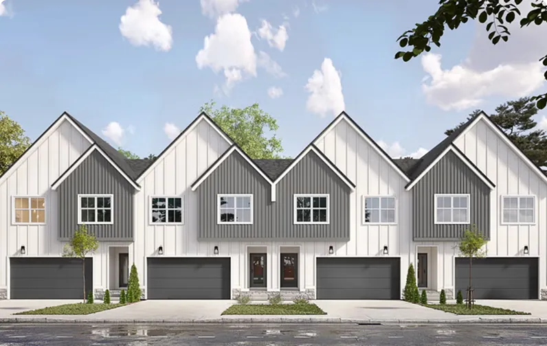 Row of modern farmhouse townhomes with white and gray siding and dark garages