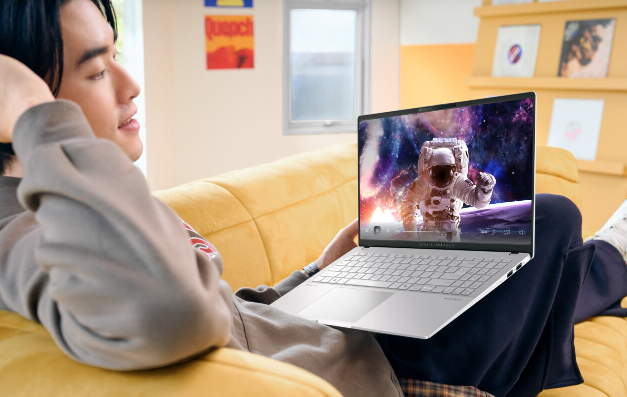 A person sitting on a couch holding a computerDescription automatically generated A person sitting on a couch holding a computerDescription automatically generated