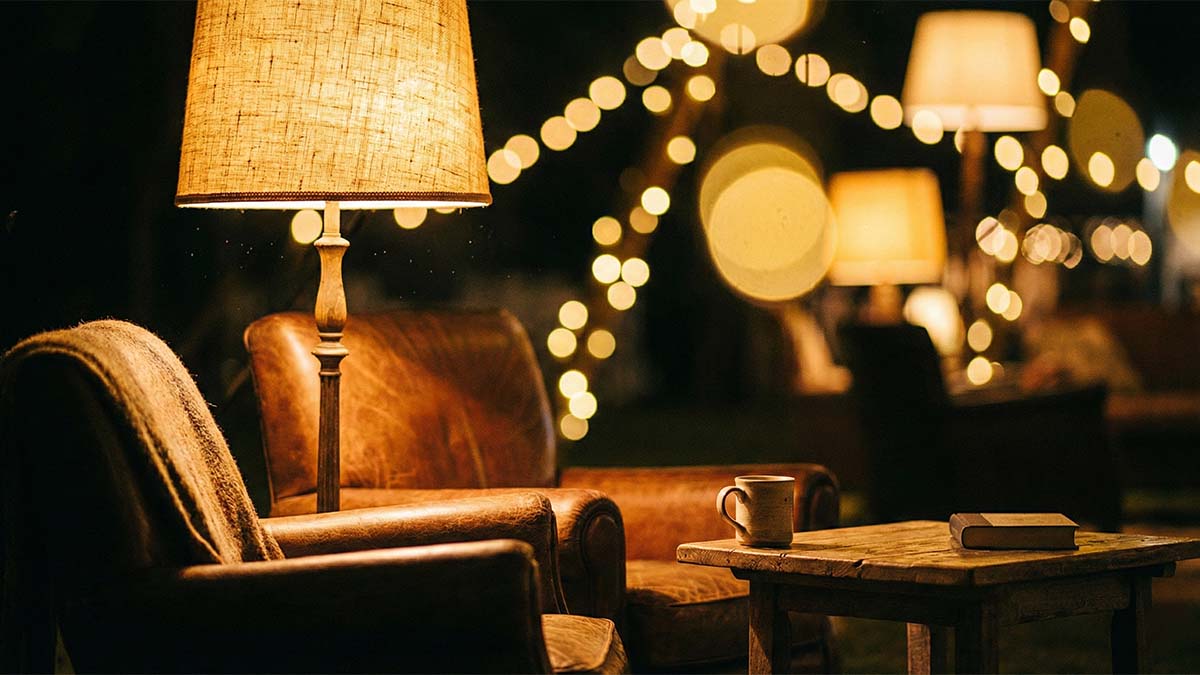 Пример грамотного освещения: торшеры и локальный свет создают уютные островки в большом зале.