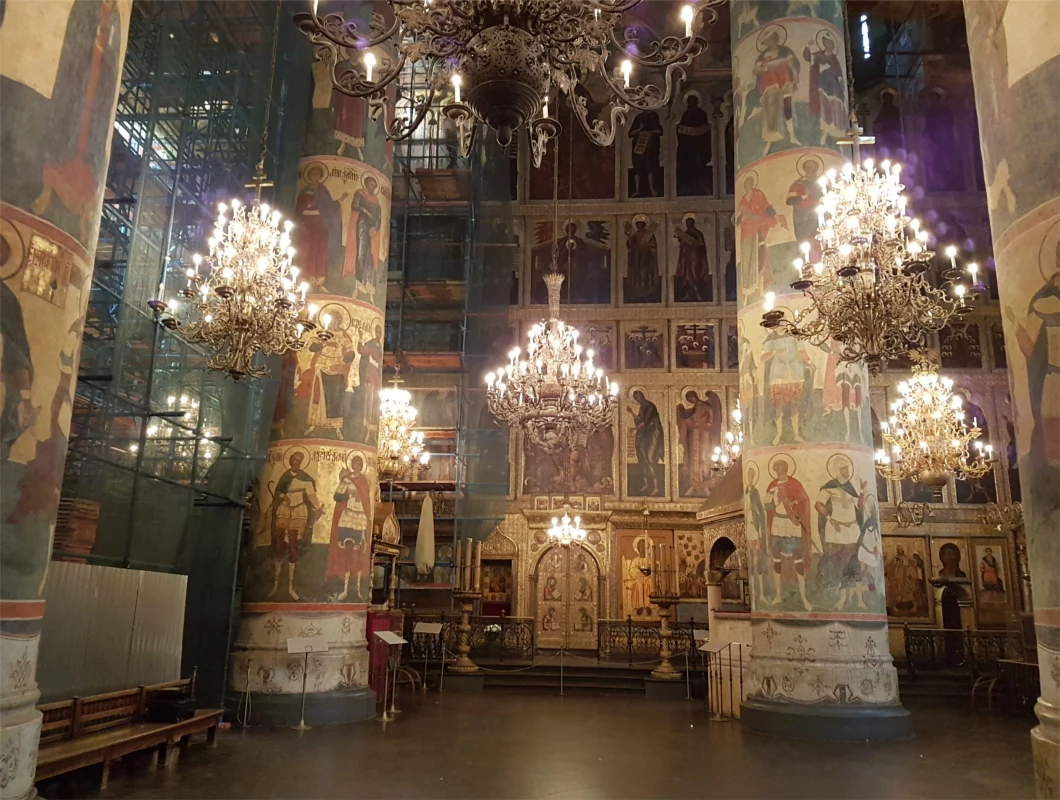 Interior view with frescoed walls and chandeliers inside a Kremlin cathedral