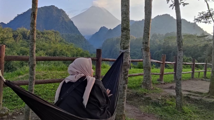 Pengunjung sedang menikmati pemandangan Gunung Merapi di Nawang Jagad pada Sabtu (8/4/2023).