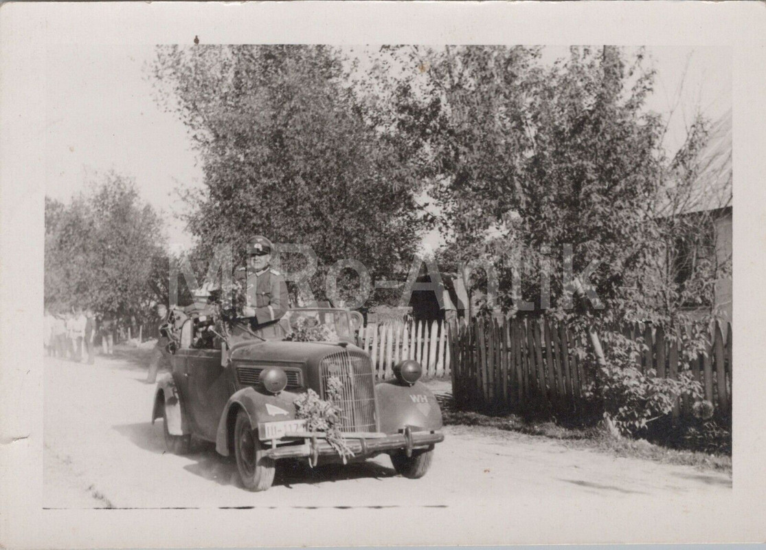 Foto, Offizier steht im Pkw Cabriolet mit Blumenstrauß,
