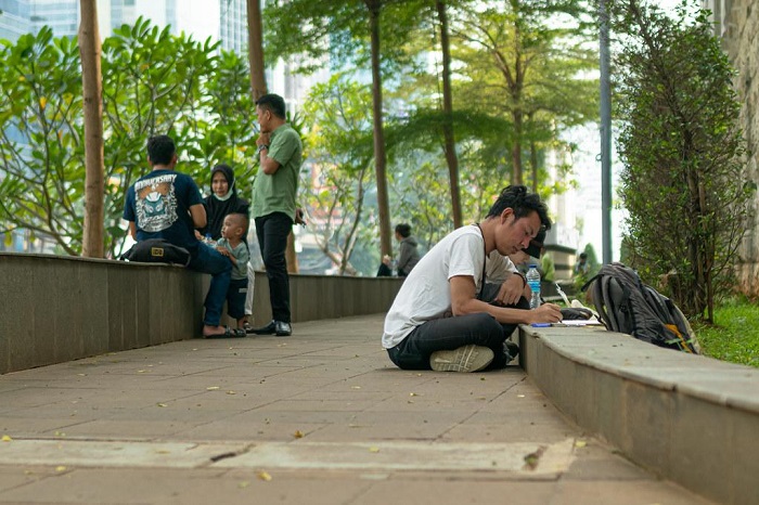 Pembuat sketsa sedang membuat karyanya di Taman Dukuh Atas. Area publik yang nyaman akan mendorong tumbuhnya aktivitas kreatif masyarakat.