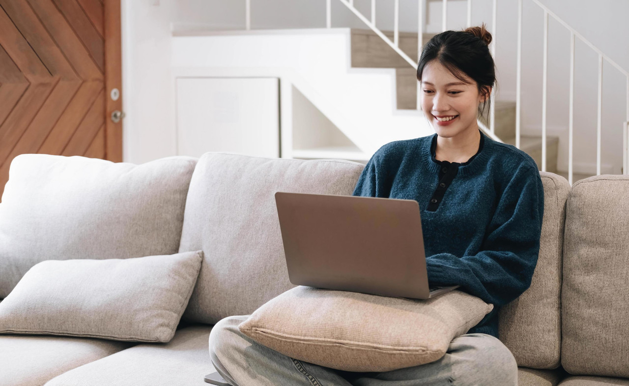 Customer relaxing on a sofa with laptop