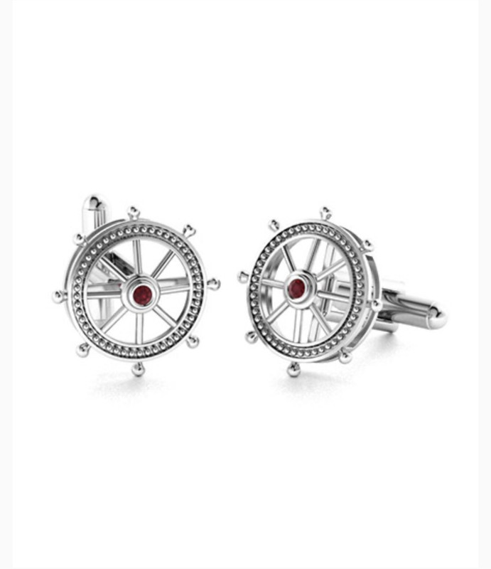 Silver cufflinks shaped like the steering wheel of a ship with a red ruby in the center