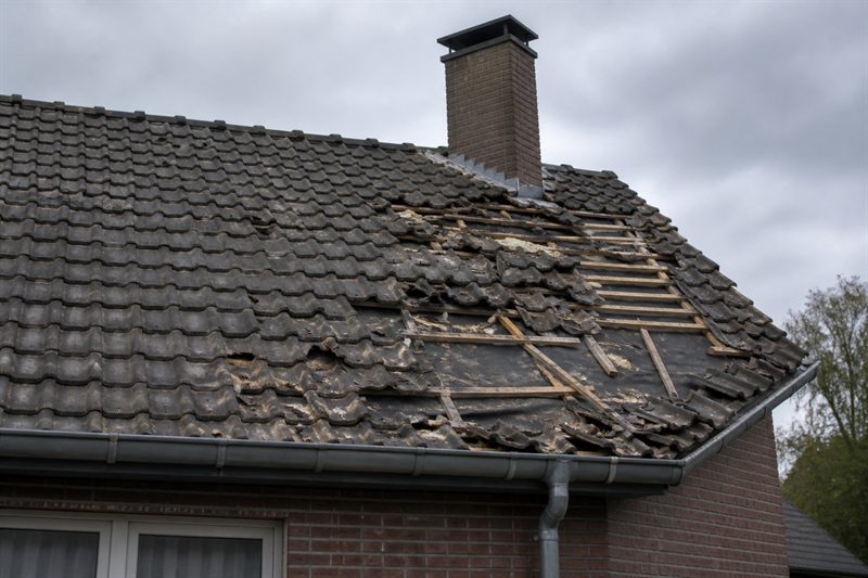 Dakwerker herstelt stormschade aan een hellend dak