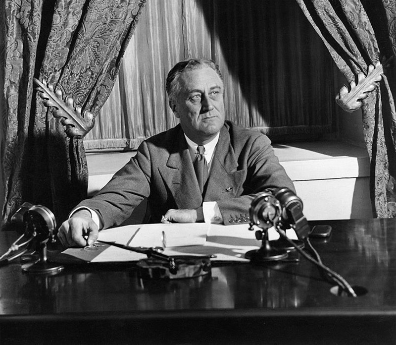 President Franklin Delano Roosevelt seated behind his desk in the oval office