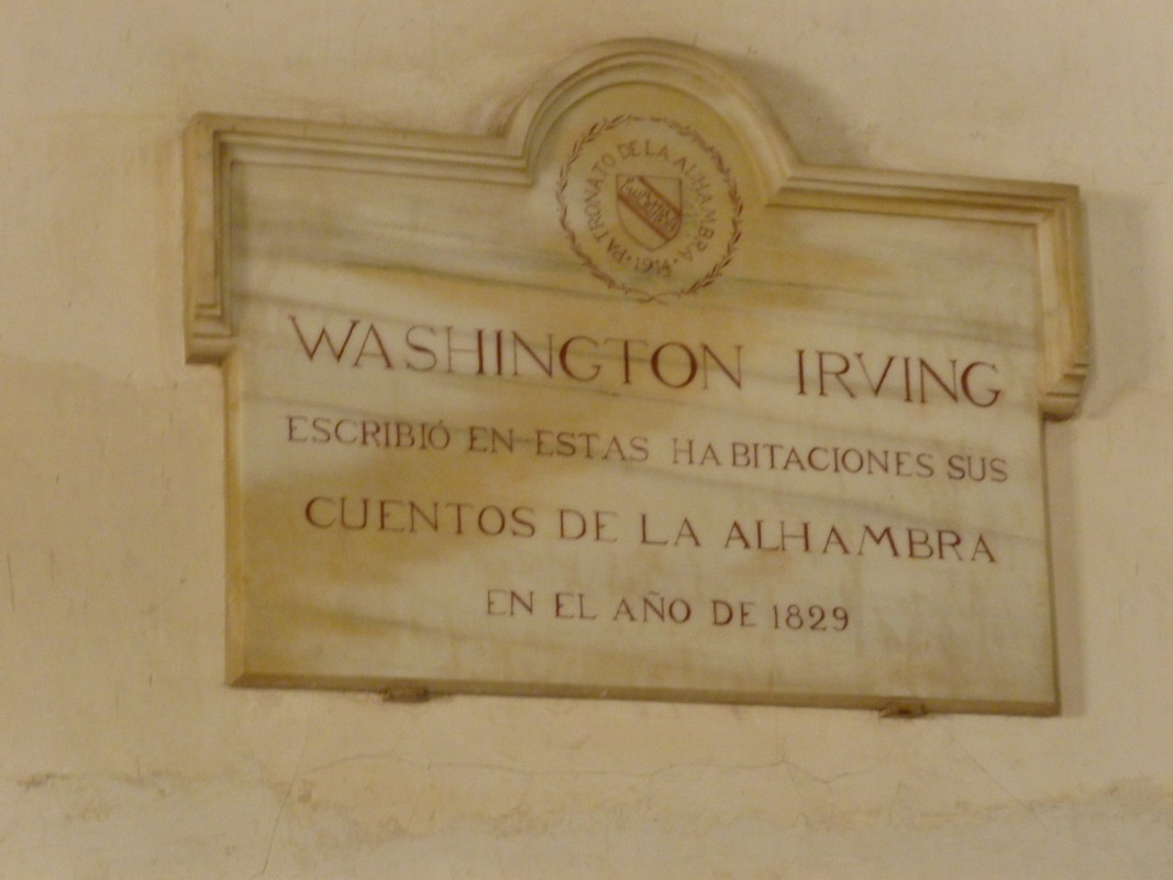Stone plaque dedicated to Washington Irving. It says "Washington Irving, escribo en estas habitaciones sus cuentos de la Alhambra en el ano de 1829." Which translates to something like "Washington Irving wrote his stories of the Alhambra here in the year 1829.