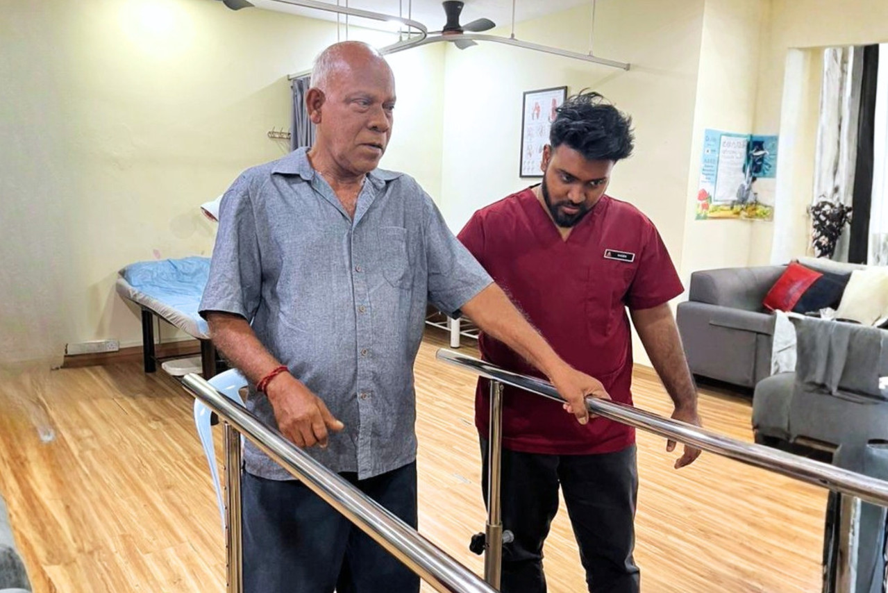 Terapis membantu warga emas dengan latihan keseimbangan