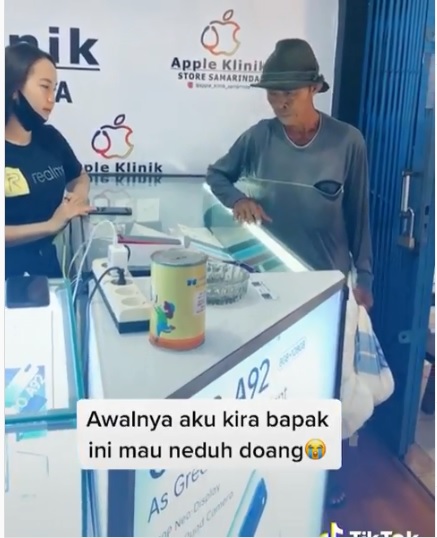 Kakek Yatmin saat melihat ponsel dengan membawa uang koin sekarung