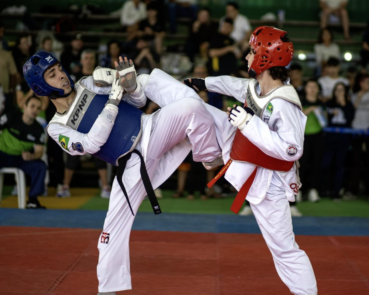 Giovanni Aubin com medalha em pódio internacional de taekwondo