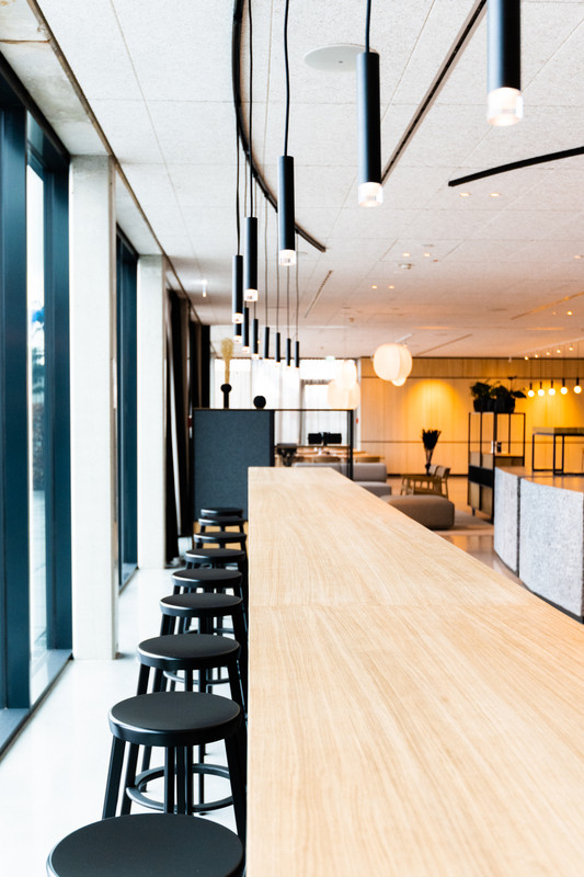 COREUM Hotel Restaurant Lichtdetail mit warmem architektonischem Licht, Hospitality-Atmosphäre und präziser visueller Zonierung