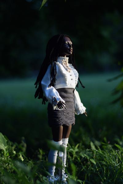 Ophelia standing in a field under some trees