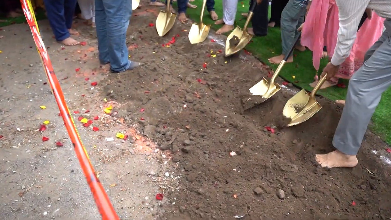 Congregation members turning soil with golden shovels at the Gurudwara Sahib groundbreaking