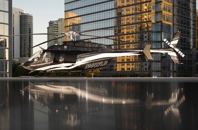 Bell 407 helicopter beside an ILandMiami yacht on Biscayne Bay