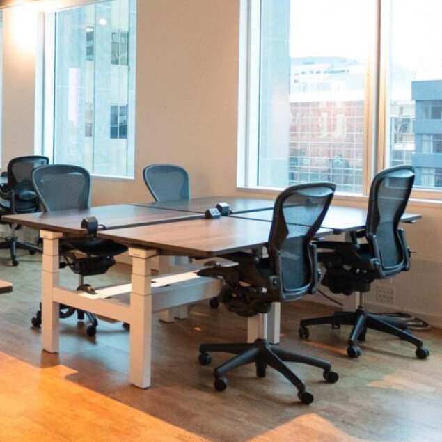 Set of desks and chairs positioned in a team setting at the window