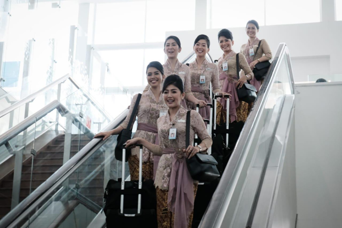 Pramugari Garuda Indonesia saat menuruni eskalator.