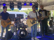Ailton Souza com banda em apresentação ao vivo durante evento diurno