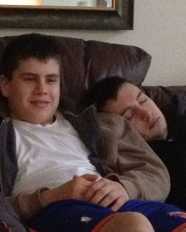 [Tyler and Jay are both on the couch, Tyler is having a nap. Tyler is leaning his head against a teenage Jay’s shoulder. He is wearing a hoodie and a grown out buzzcut. Jay is shorts, a white tshirt and a zip up hoodie]