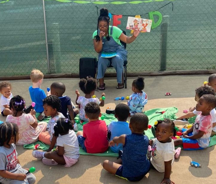 A caring teacher reading with children at 1st Step Learning Academy