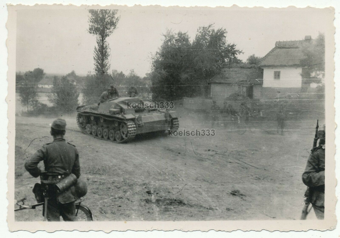 Foto Sturmgeschütz Panzer der Wehrmacht rollt durch ein Dorf an der Ostfront