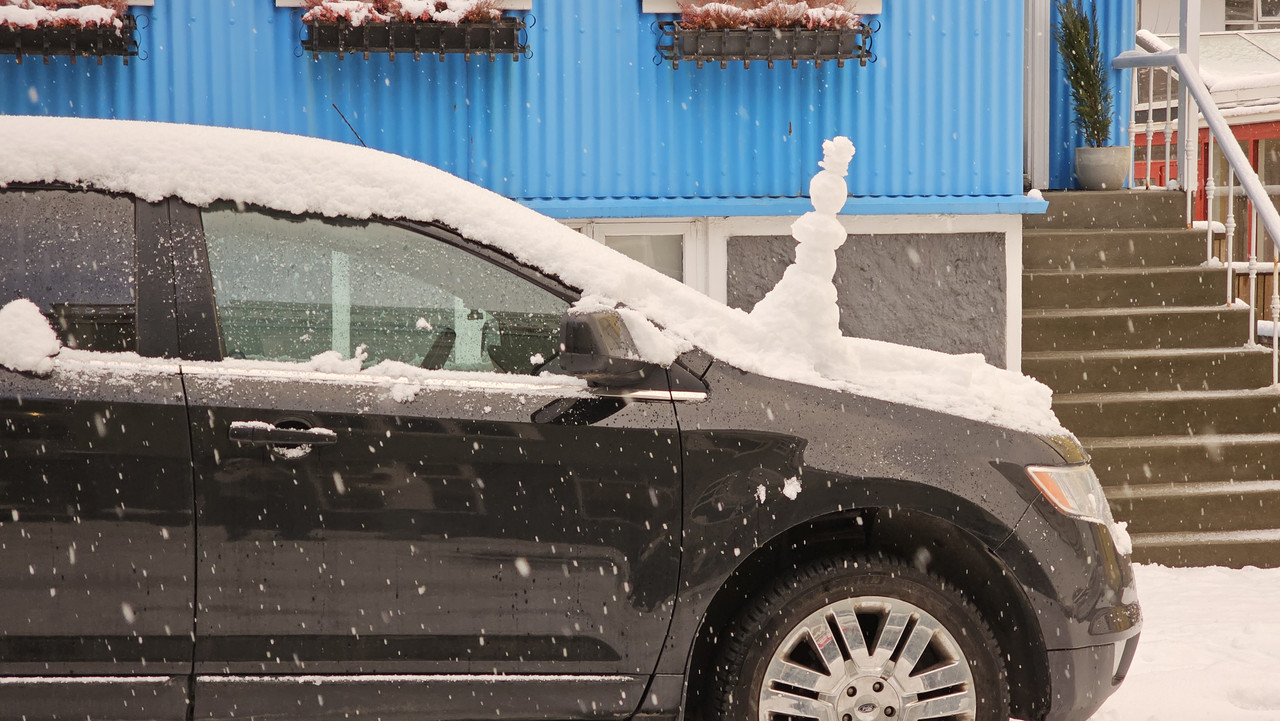 路邊車上有雪人，是的晴朗的天氣沒了，又開始下雪了