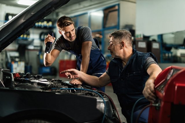 The Importance of Regular Car Battery Maintenance Auto-mechanics-communicating-while-doing-diagnostic-air-conditioning-system-workshop-min-Easy-Resize
