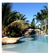 Shivo Gardens tropical lagoon-style resort swimming pool with turquoise water, palm trees, sun loungers, and luxury villas in background at Paje Beach Zanzibar beachfront development