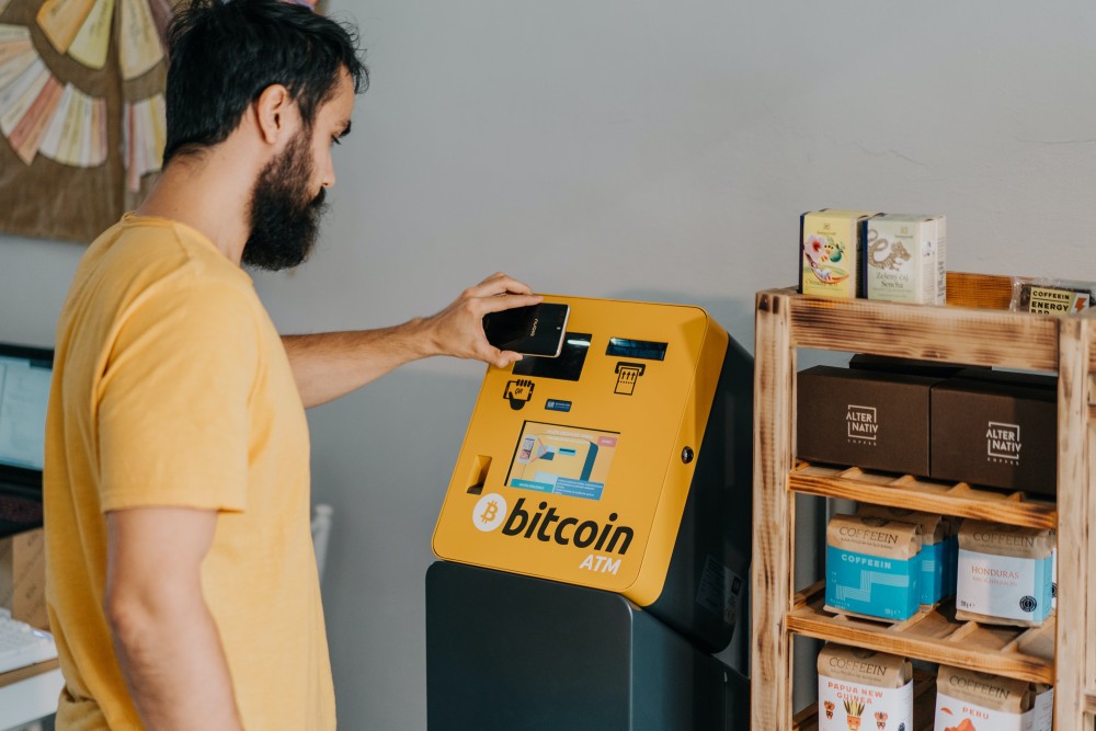 A man standing in front of a Bitcoin ATM